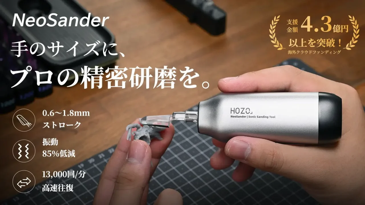 手のひらサイズの精密電動サンダーNeoSanderを持ち、小さな造形物を研磨する様子