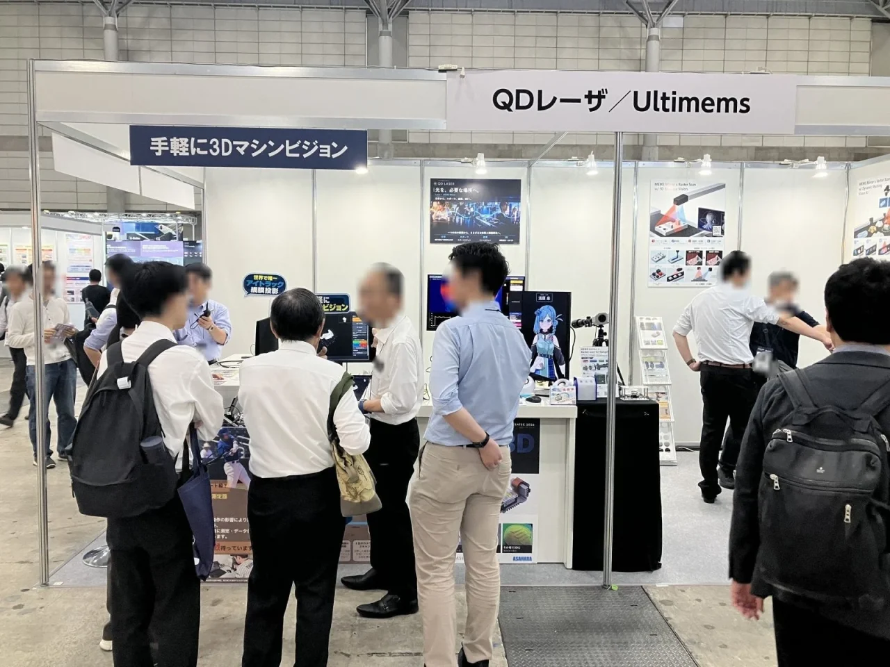 CEATEC会場のQDレーザ／Ultimemsブースで来場者が展示を見る様子