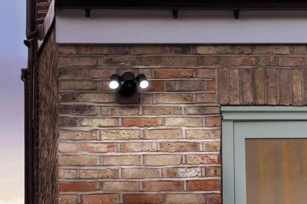 レンガ壁に取り付けられたLGのFloodlight Cam、両側のライトが点灯