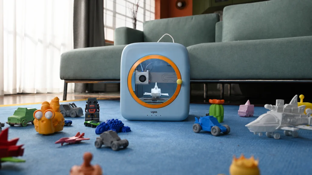 リビングの床に置かれた青い丸窓の3Dプリンター「Funbox」と周囲のおもちゃ