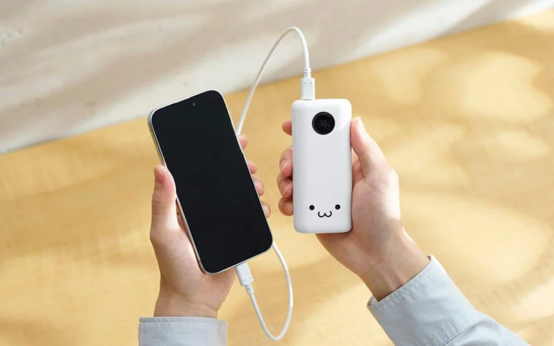 DE-C96L-6000WF(しろちゃん)をケーブルでスマホに接続し手に持つ様子
