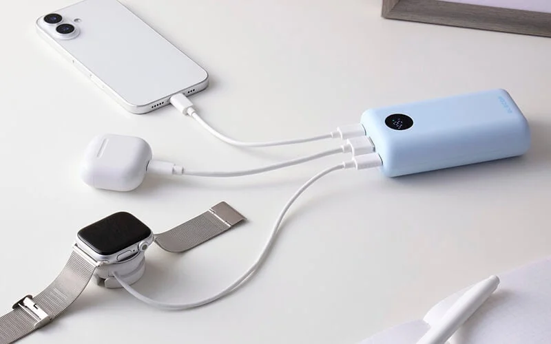 水色のモバイルバッテリーからスマホ・イヤホン・時計を同時充電する様子