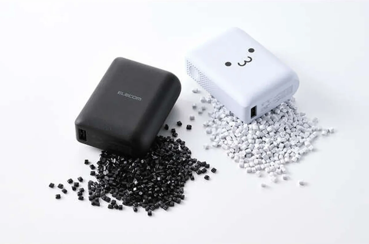 黒と白のモバイルバッテリーと、周囲に散らばる黒と白の樹脂ペレット