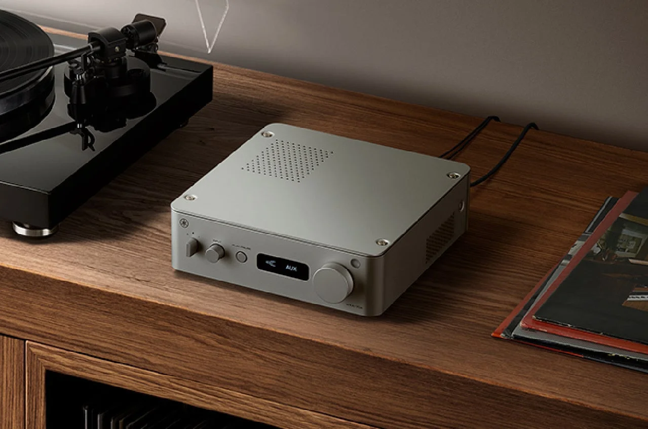 木製の棚に置かれたシルバーのコンパクトなアンプとレコードプレーヤー