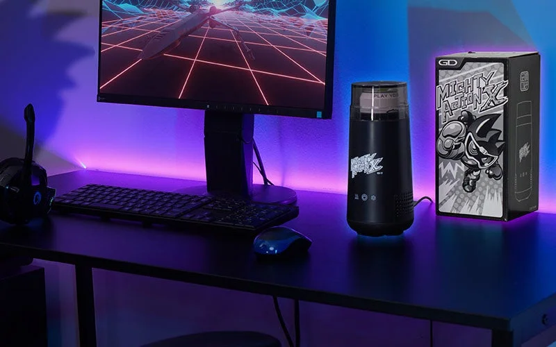 ゲーマー専用エナドリ缶クーラー「プロトマイティアクションXオリジン」と化粧箱をデスクに置いた様子