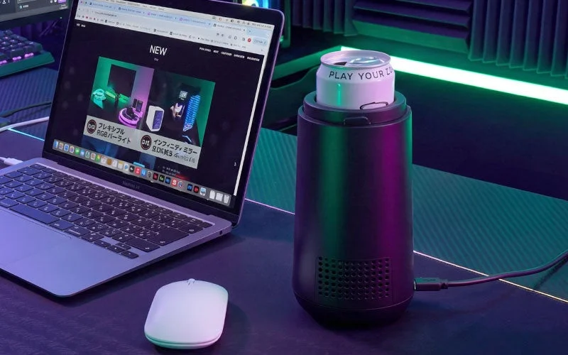 ノートPCとマウスの横に置かれた、缶をセットした黒いエナドリ缶クーラー