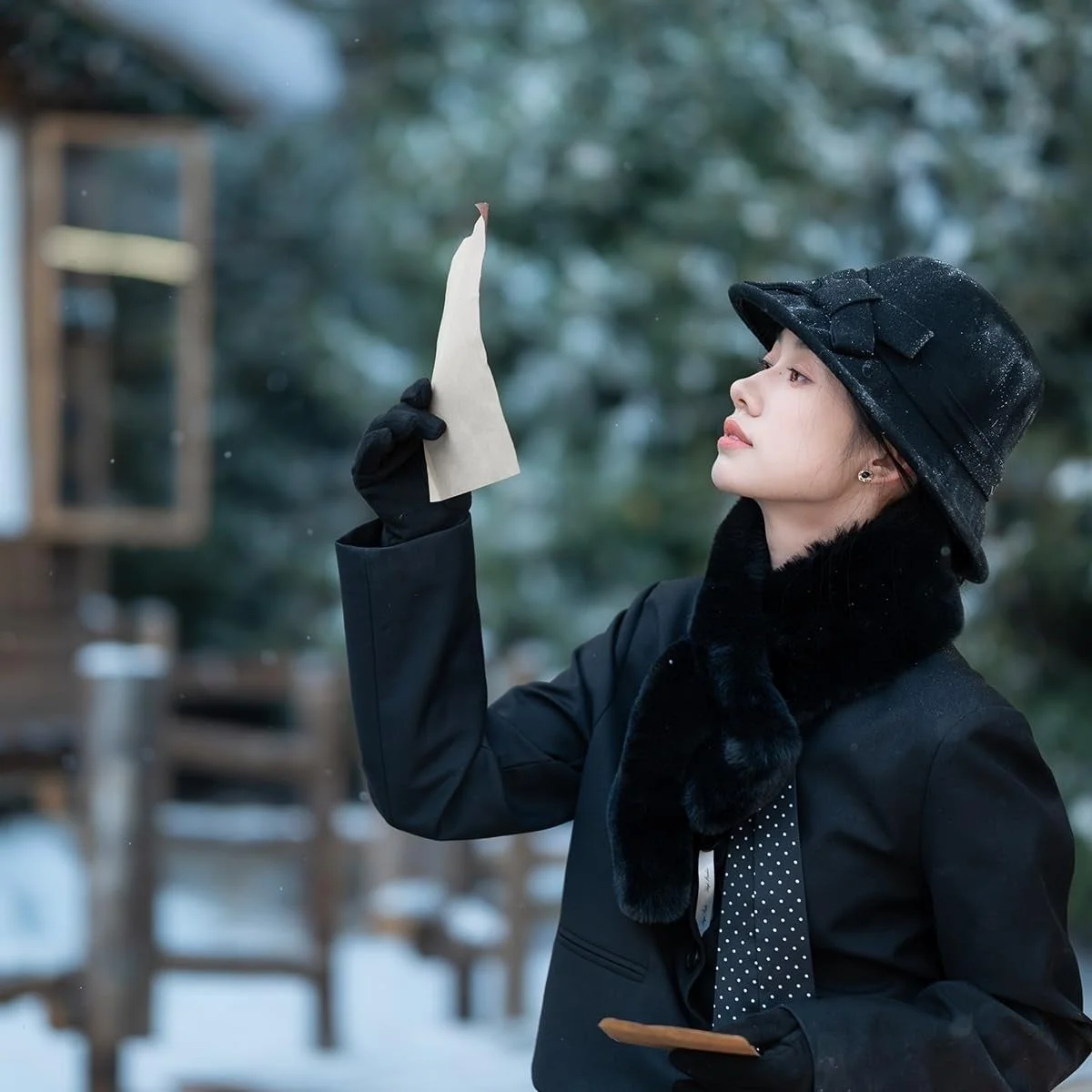 AF 56mm F1.2 PRO Z作例。雪の中で黒い帽子とコートの女性が横を向く