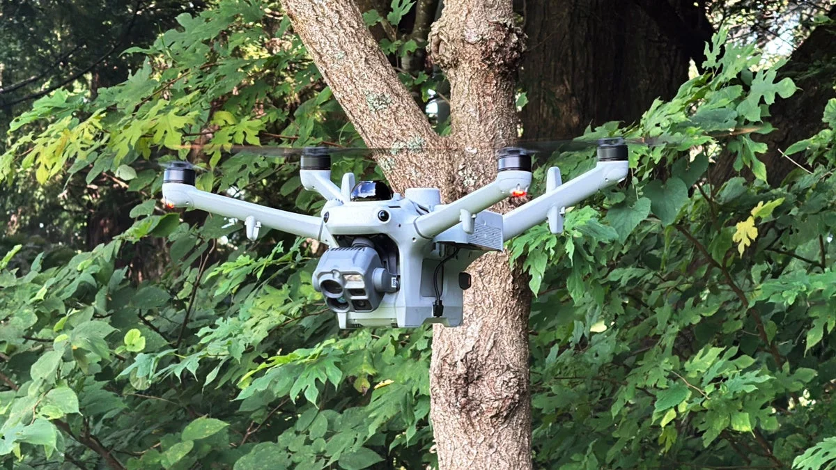 木の前でホバリングするDJI Matrice 5TD。下部にカメラを搭載
