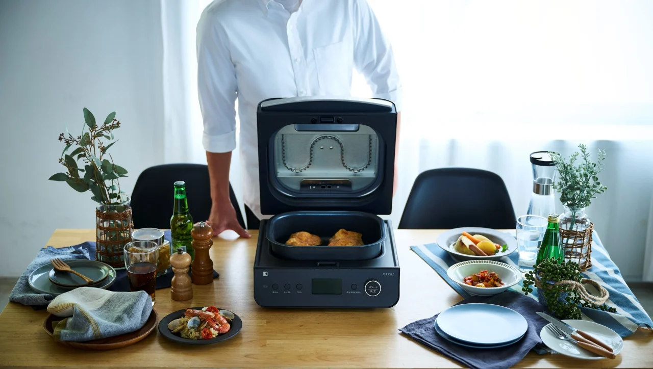 食卓に置かれたマルチグリルクッカー GRISIA CLX-A400。ふたを開け、鶏肉の料理が入っている