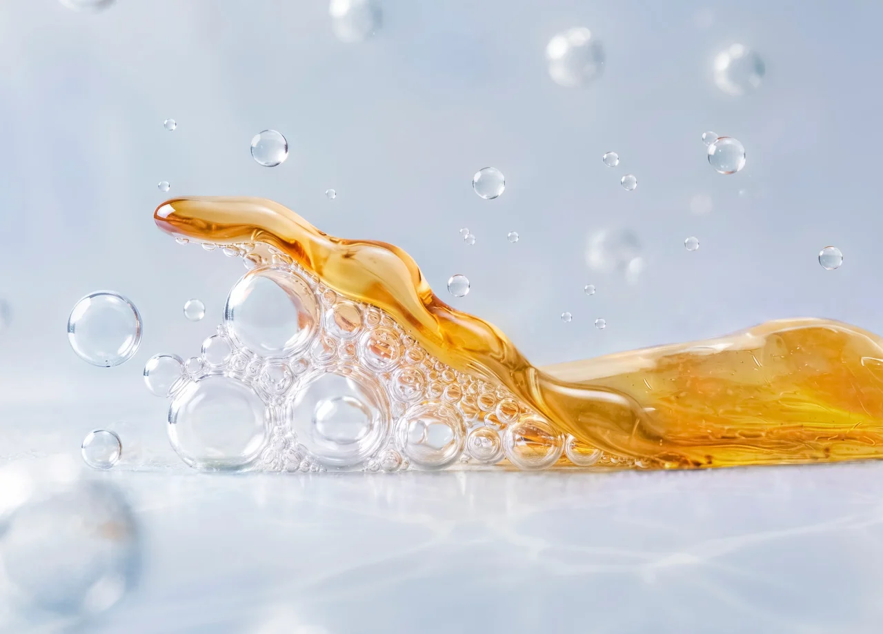 汚れをはがしとる様子を表す、泡と琥珀色の油状の液体のクローズアップ
