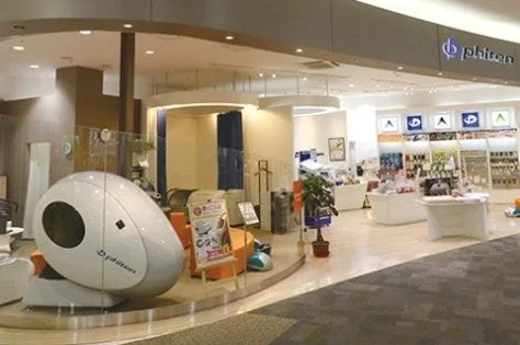 ファイテンショップの店内。卵型の白い機器と商品棚が並ぶ
