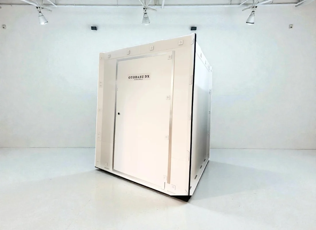 白い部屋に置かれた組み立て式簡易防音室OTODASU DX145の外観