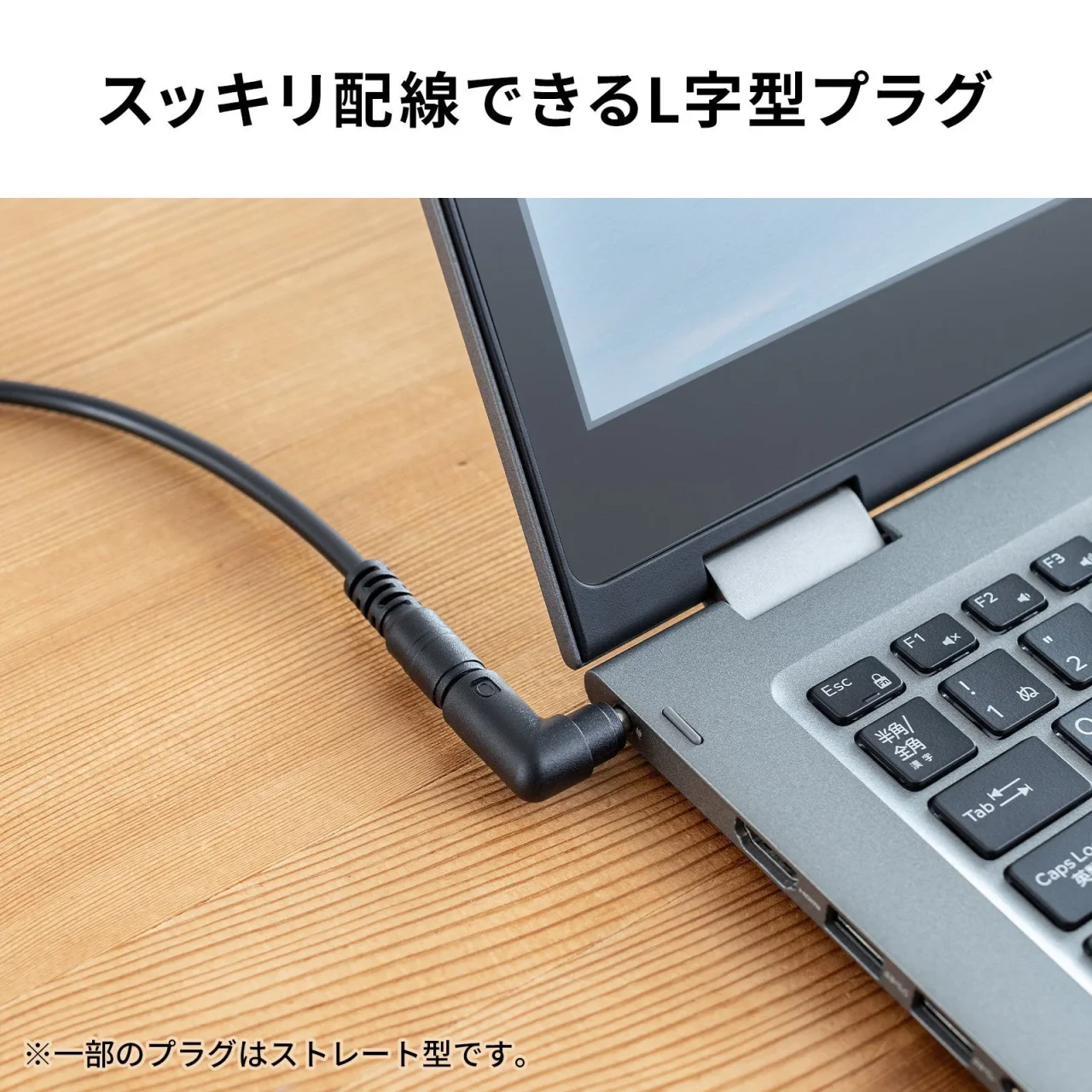 ノートパソコンに接続された黒いL字型プラグ