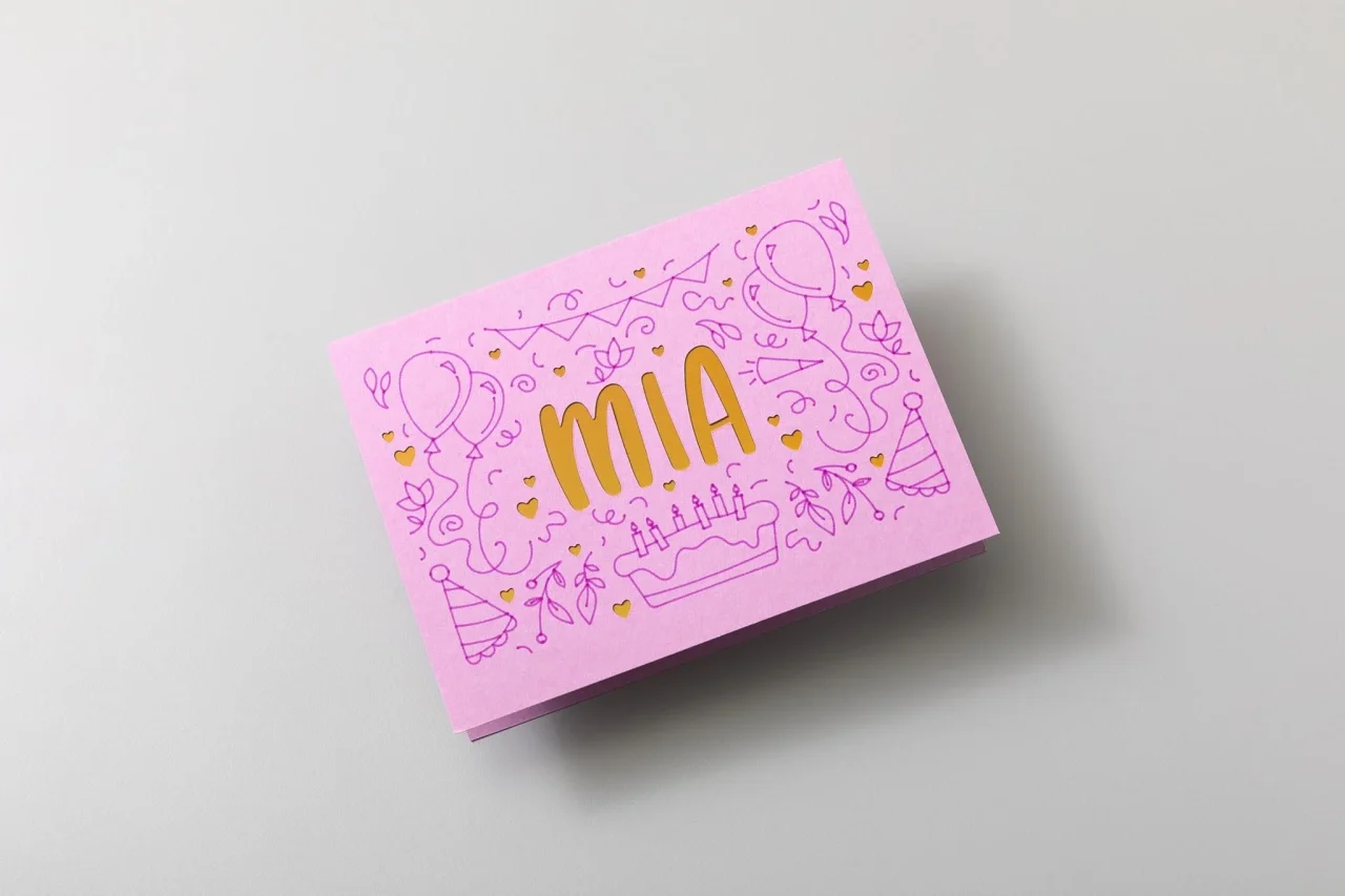 ペンとカットを組み合わせたカード。ピンク紙に「MIA」の金色の切り抜き