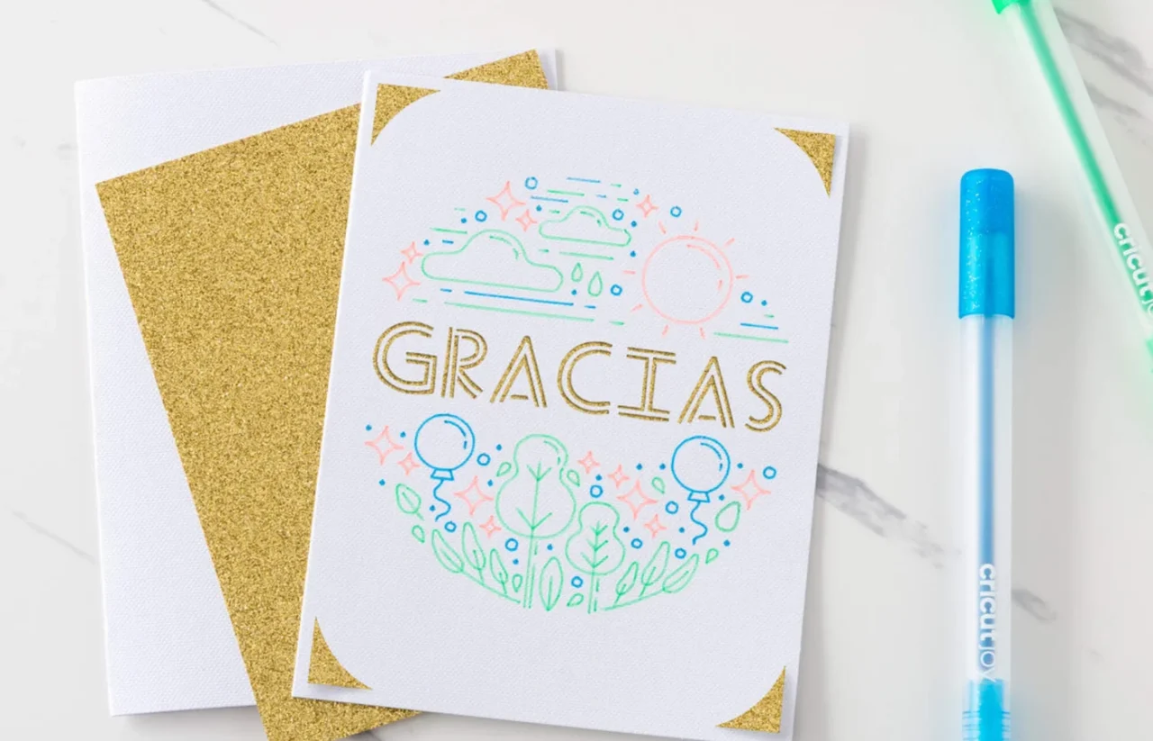 グリッタージェルペンで描いた「GRACIAS」のカードと金色のグリッター台紙