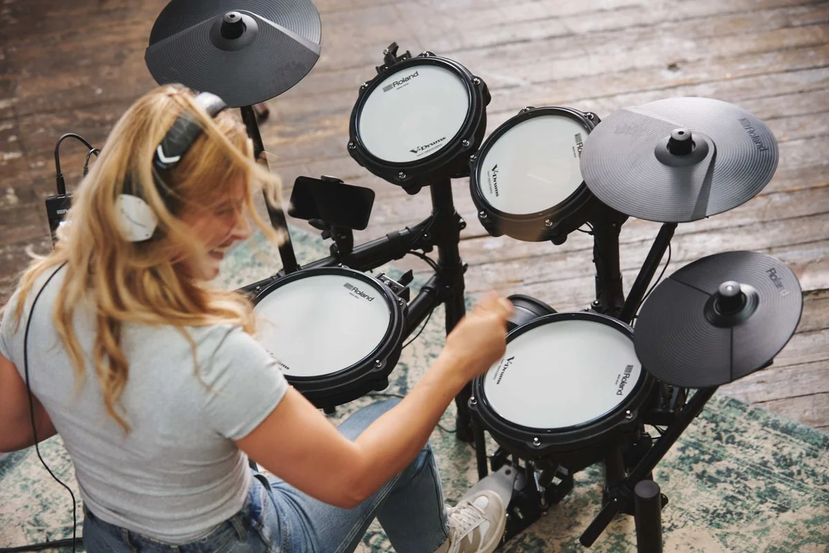 『TD-07KV2』演奏イメージ。ヘッドホンの女性が電子ドラムを叩く