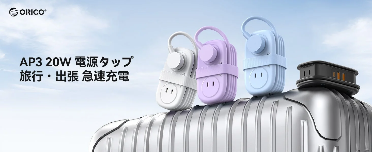 スーツケース上に並ぶ巻き取り式トラベル電源タップの白・紫・青とブラック