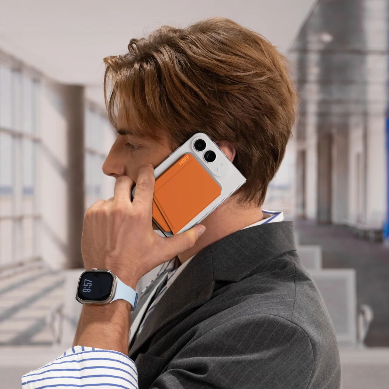 MOFT 折りたたみ式カードケース＆スタンドを背面に付けたスマホで通話する男性