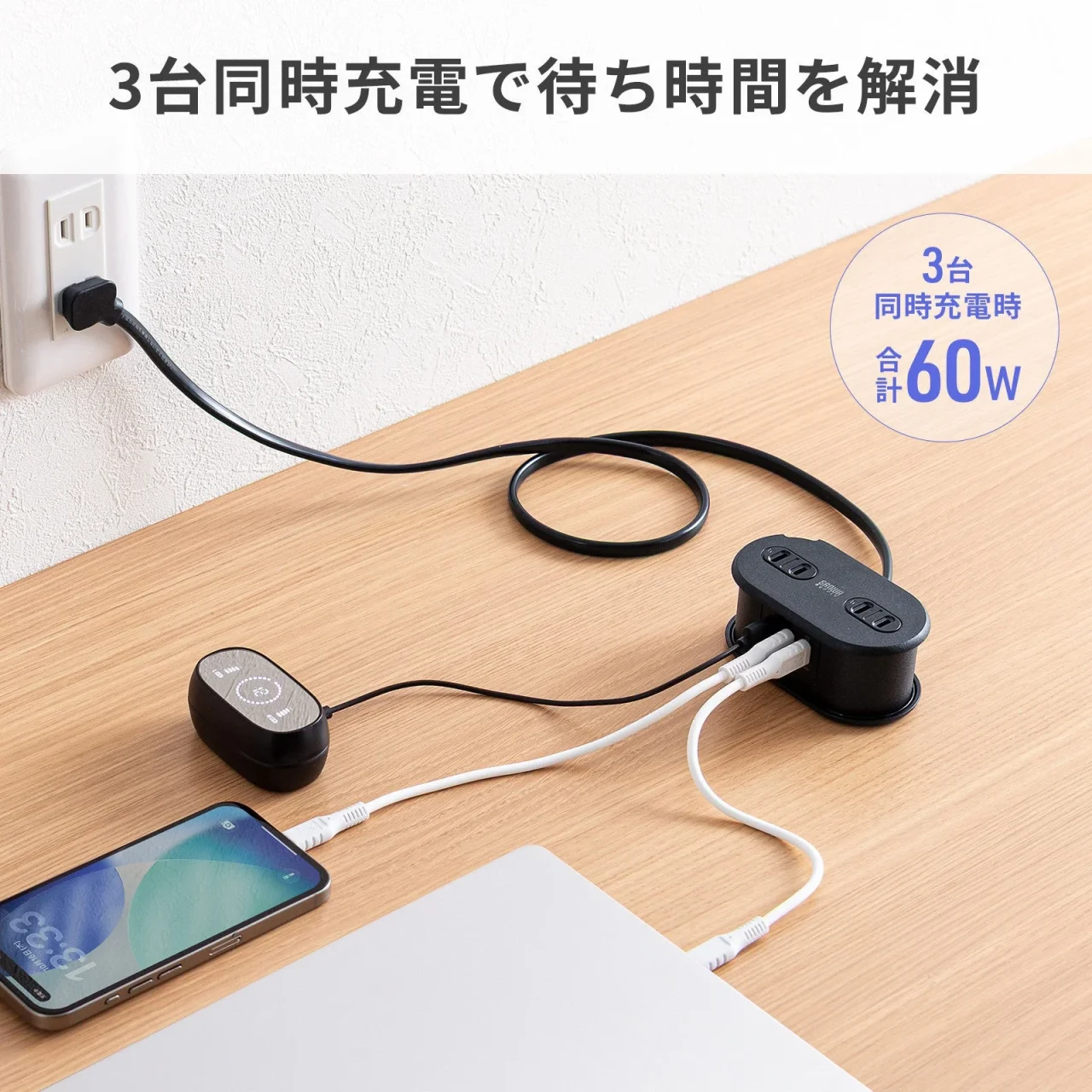 コード付き黒いモバイルタップでスマホなど3台を同時充電する様子