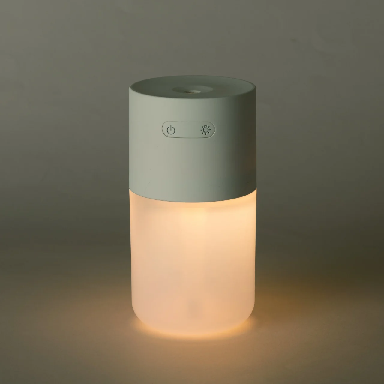 ライトが点灯したコードレスデスク加湿器。円筒形で上部は緑がかった白