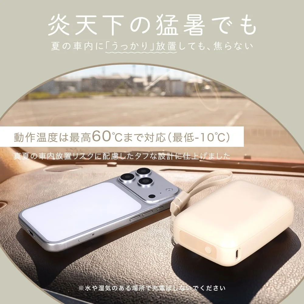 夏の車内ダッシュボードに置かれたスマホとストラップ付きモバイルバッテリー