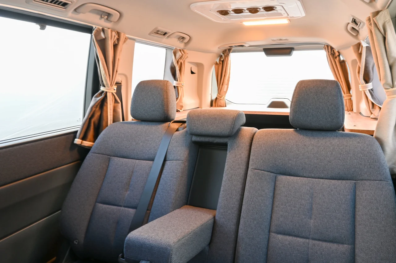 乗車モードのミニバン車内。グレーの後部座席と天井、窓のカーテン