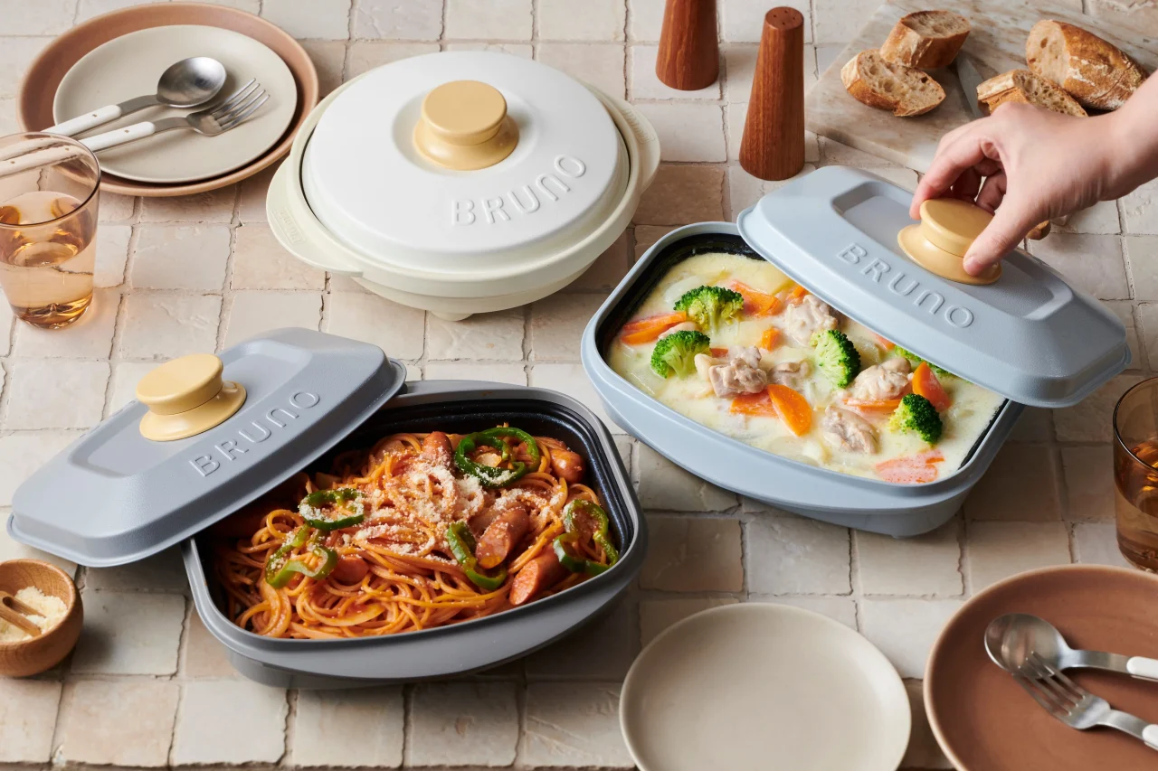 食卓に並ぶグレーのスクエア型調理器具、パスタとクリーム煮入り