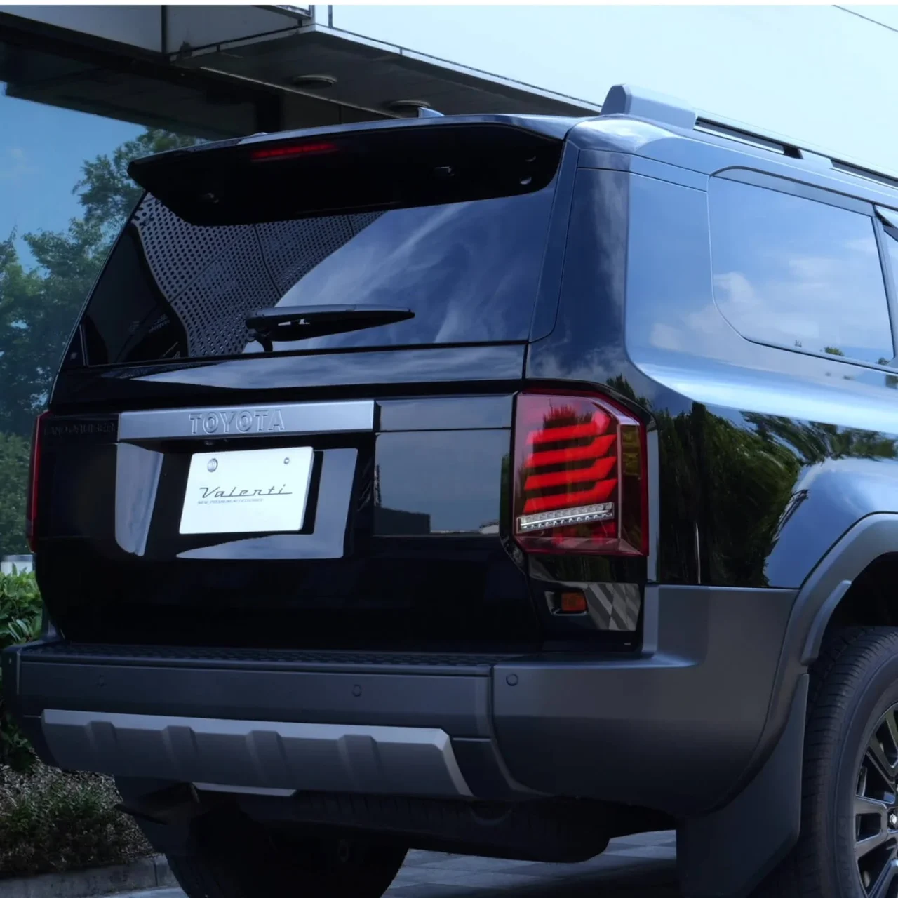 黒いSUVの後ろ姿。赤いLEDテールランプとValentiのナンバープレート