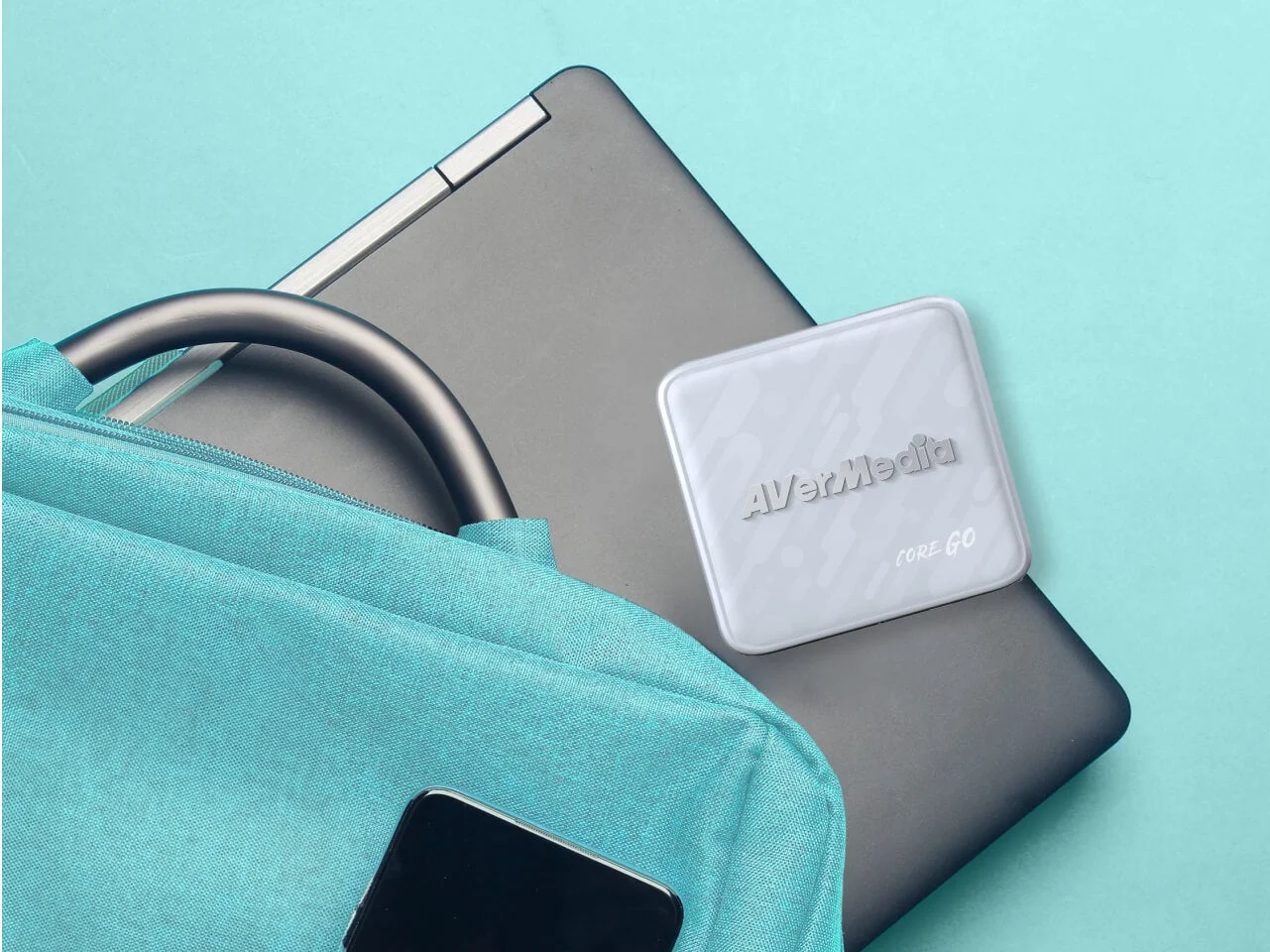CORE GO GC313の白い本体。ノートPCの上に置かれ、水色のバッグと並ぶ