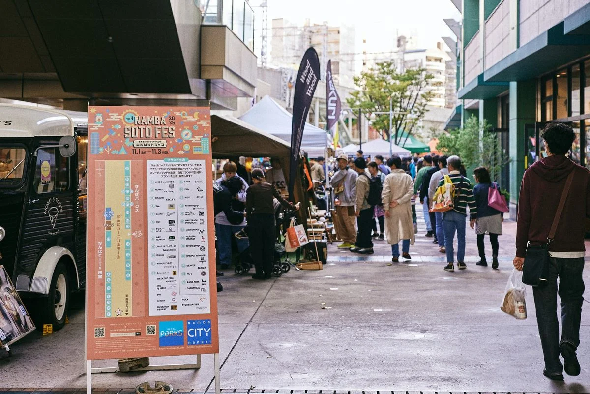 なんばソトフェスの会場風景。案内看板の前を来場者が歩く