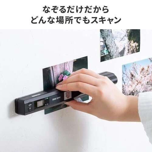 壁に貼った写真を手でなぞってスキャンするハンディスキャナ