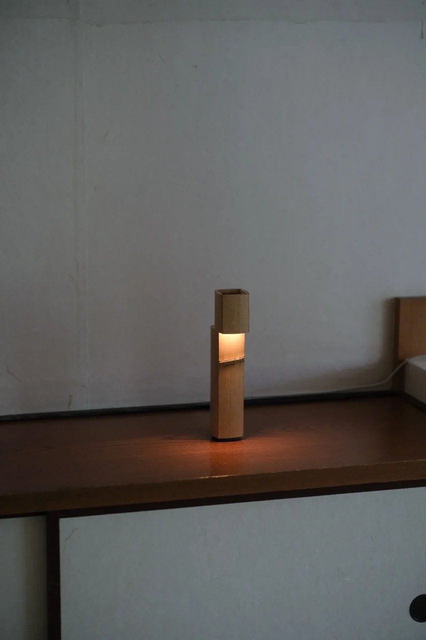 木製の棚の上で暖色に灯るNosou 0°の竹製照明