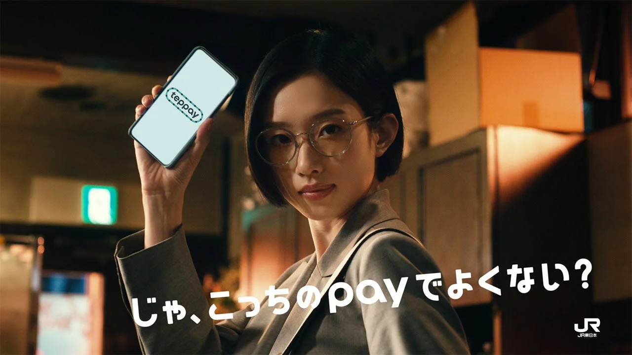 teppay新テレビCMの場面。スマホを掲げる眼鏡の女性