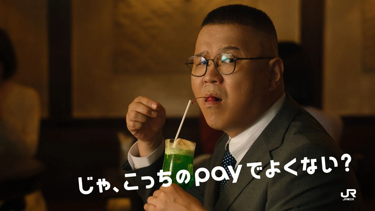 「クリームソーダ」篇のCM場面。眼鏡の男性がストローでクリームソーダを飲む
