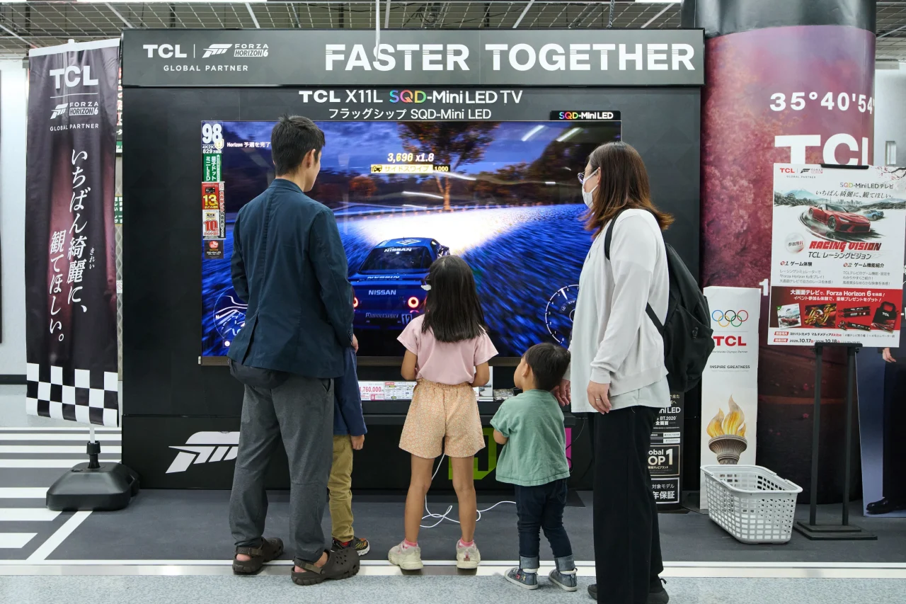TCL X11L SQD-Mini LEDテレビの展示ブースでゲーム画面を見る来場者