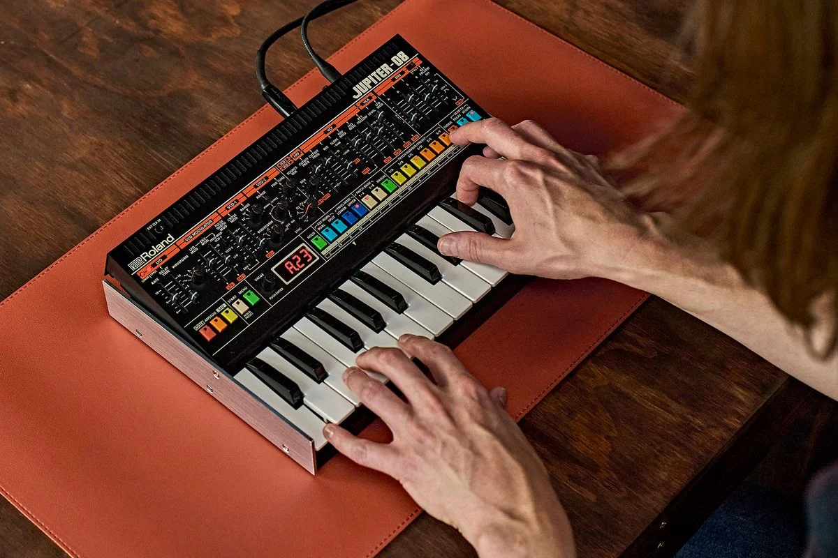 『JUPITER-08』の演奏イメージ。オレンジのマット上で鍵盤を弾く両手