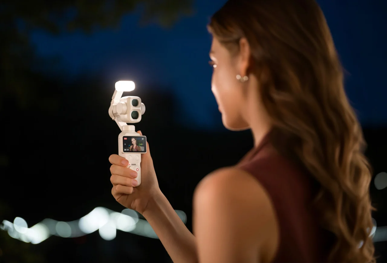 夜に補助ライトを点灯したOsmo Pocket 4P パールホワイトを手に持つ女性