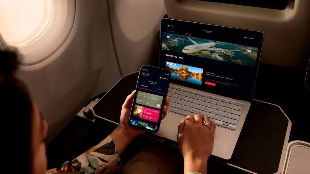 機内でノートPCとスマートフォンを使い無料Wi-Fiに接続する乗客