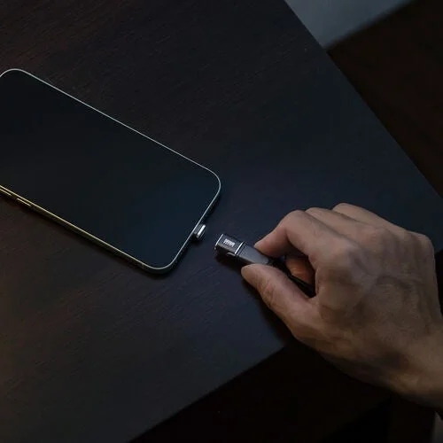 スマートフォンにマグネット式アダプタを近づけて接続する手元