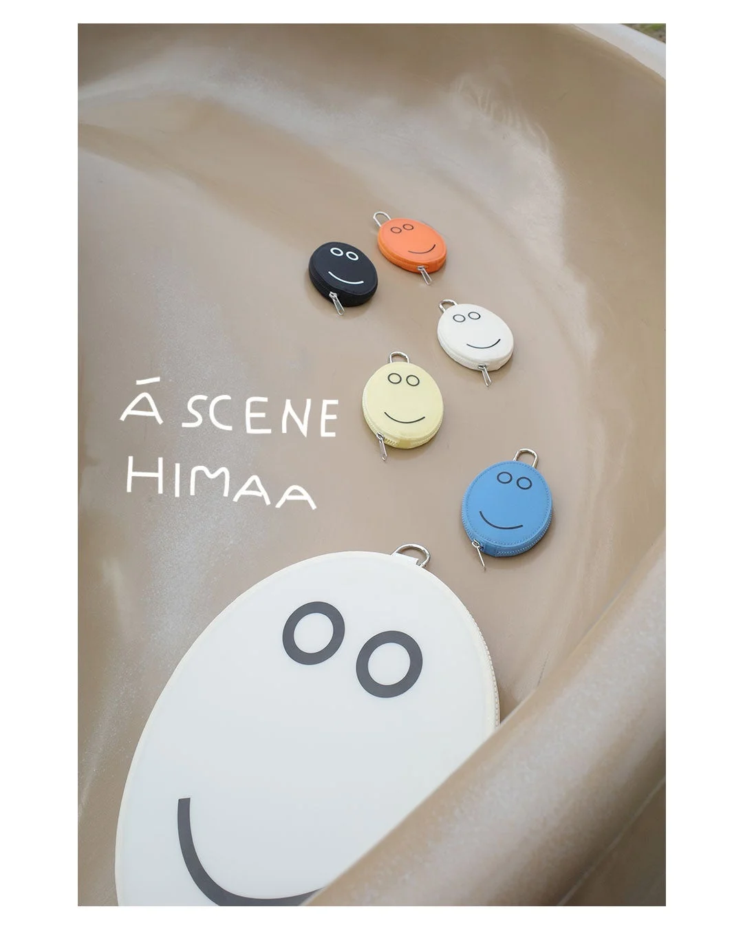 A SCENEとHIMAAのコラボ、ニコちゃん柄の5色ミニポーチと白い大判ポーチ
