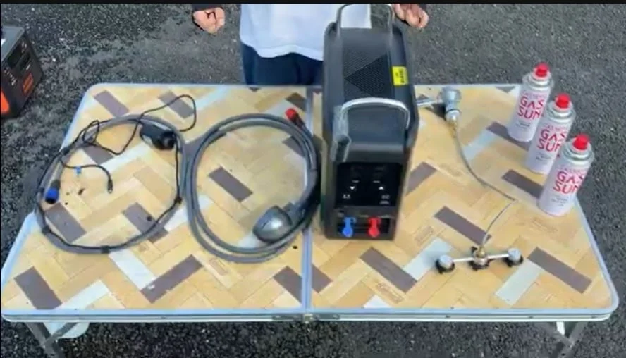 折りたたみテーブル上に並べた本体、ホース、カセットガス3本などの準備品