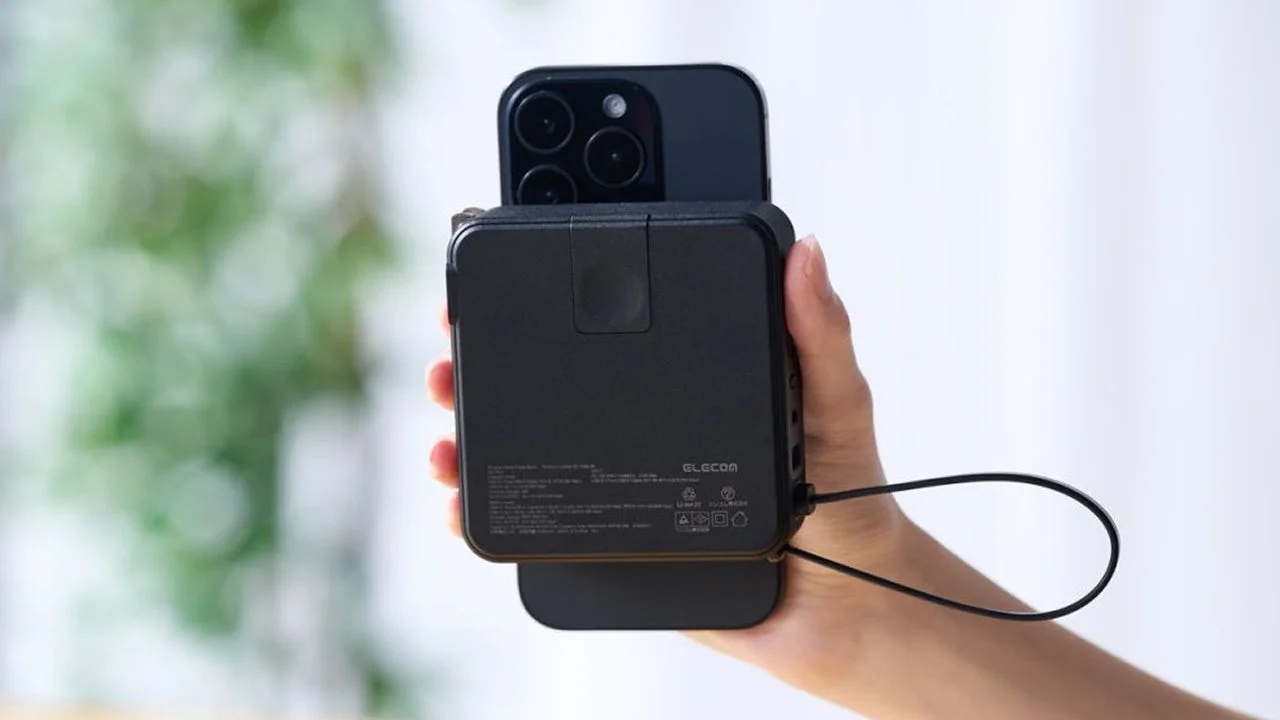 スマートフォンをマグネットで取り付けた黒いエレコム製モバイルバッテリーを手で持つ様子