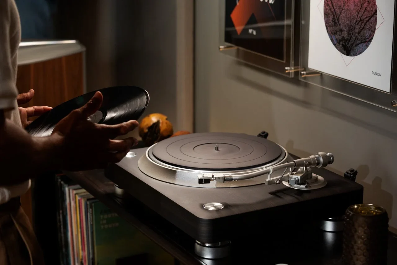 DP-3000NE ダイレクトドライブ・レコードプレーヤーとレコードを手にする人物