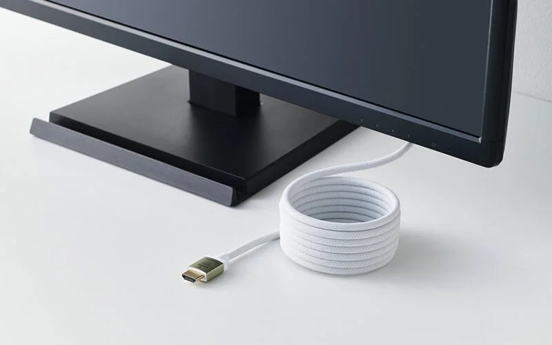 メッシュタイプ2m仕様のHDMIケーブルがモニター下で丸くまとまる様子
