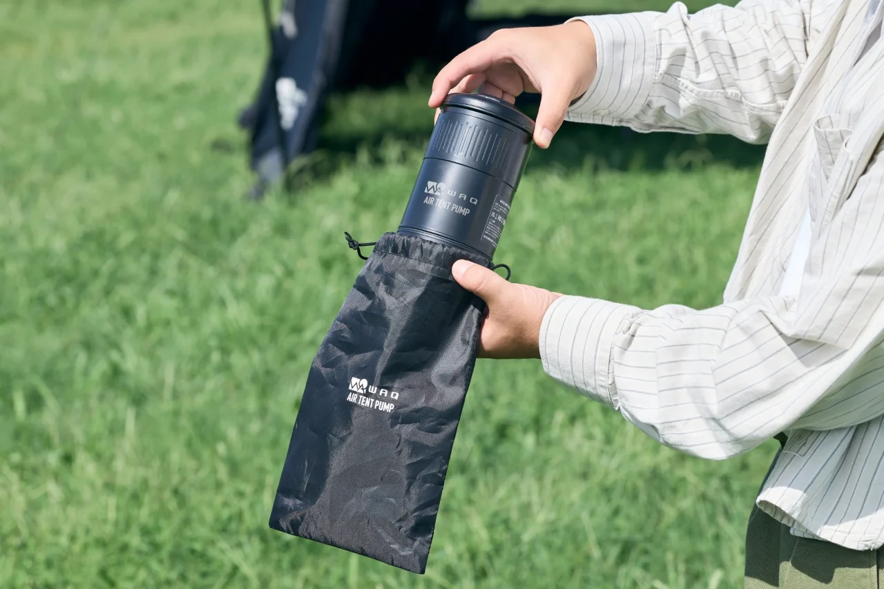 AIR TENT PUMPを黒い収納袋に出し入れする手元