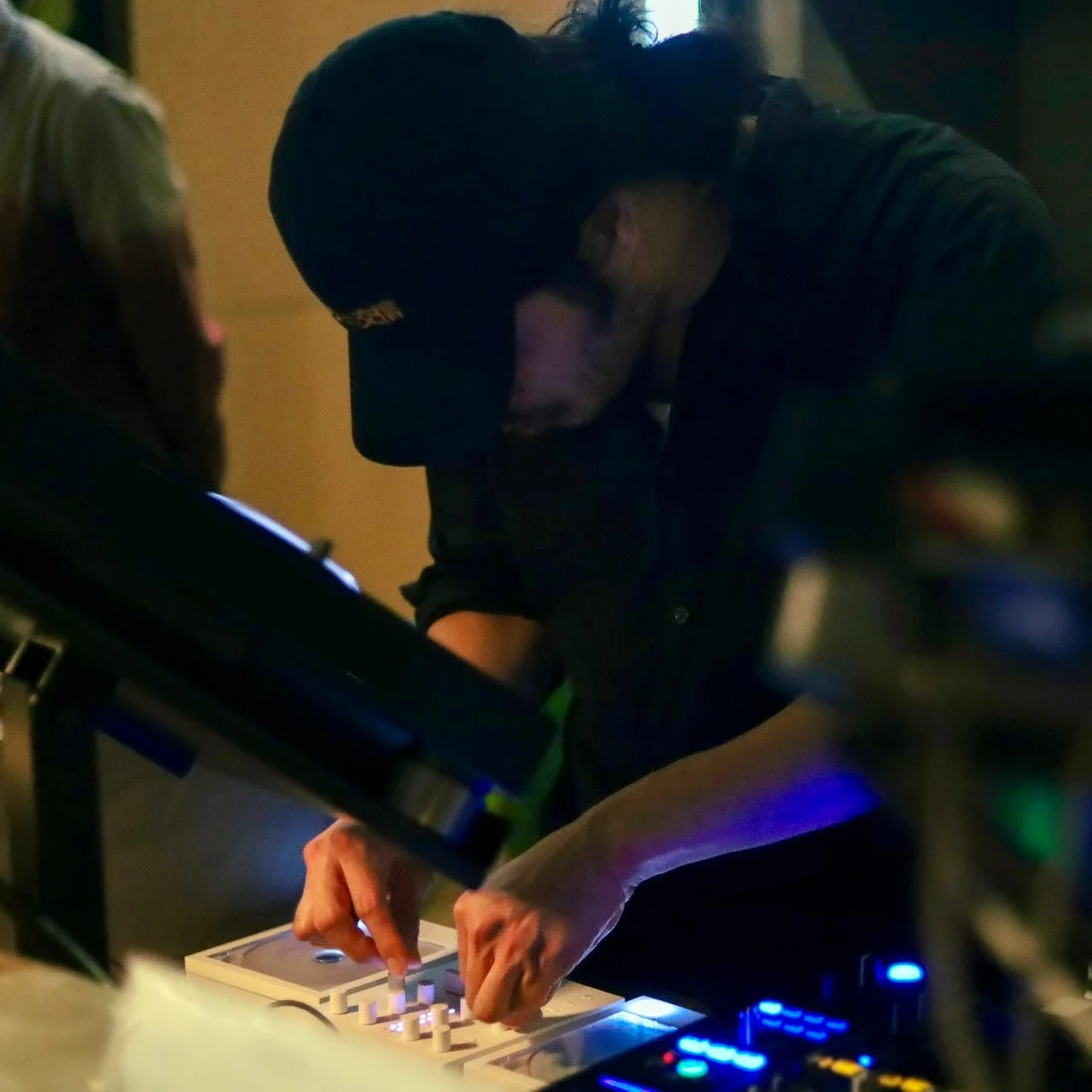 レセプションでDJセットを操作する、キャップ姿の人物の手元