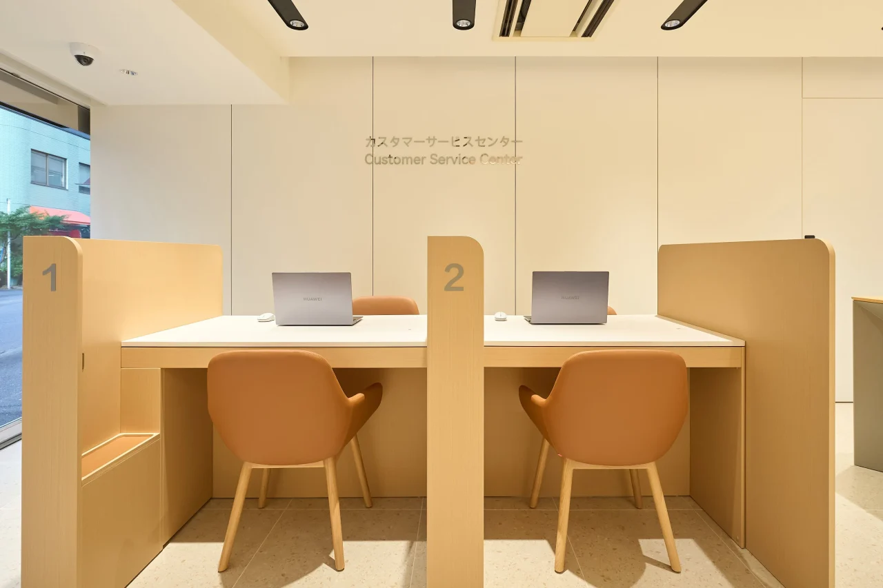 HUAWEI公式サービスセンターの相談カウンター。ノートPCと椅子が並ぶ
