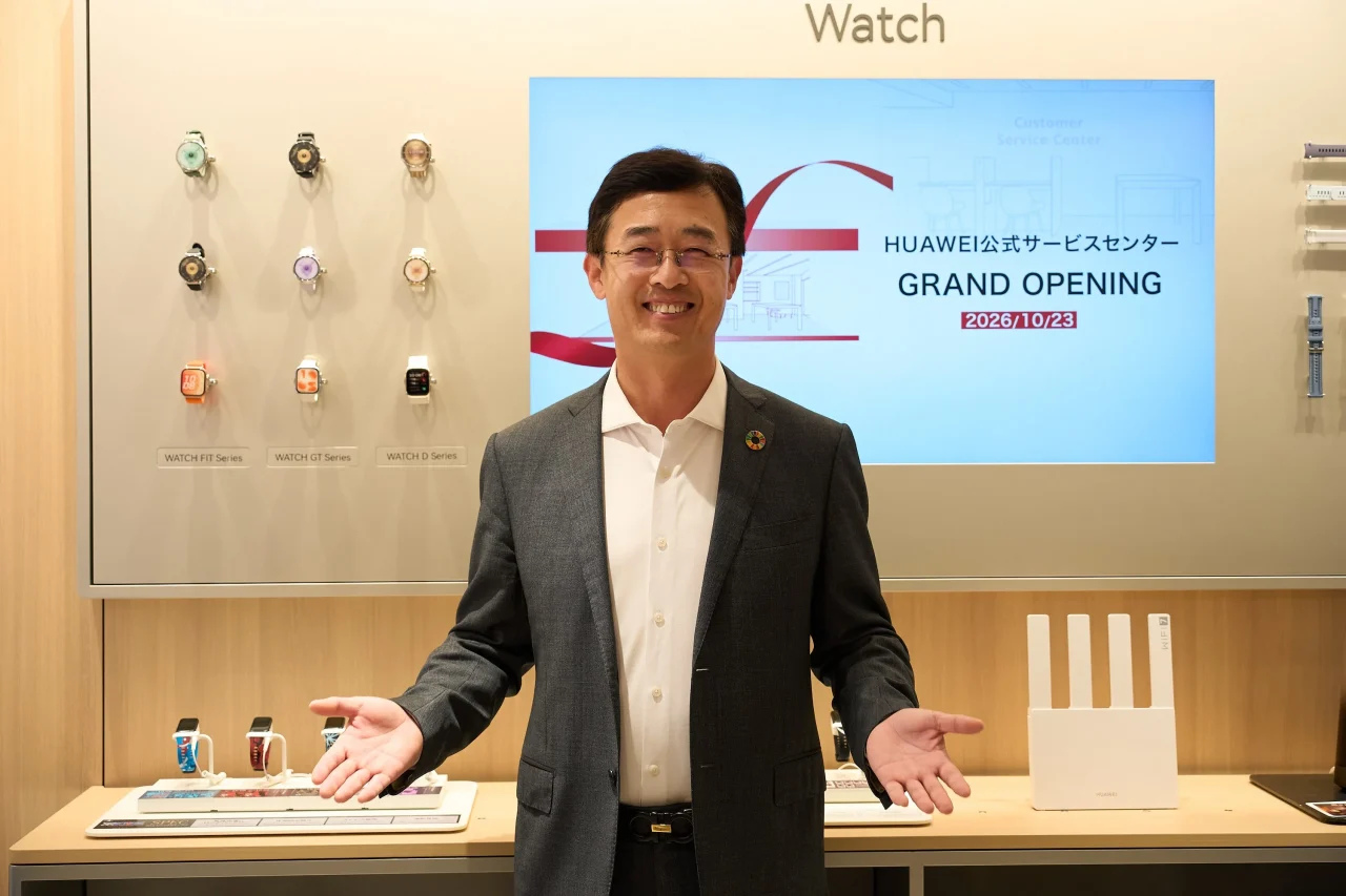 HUAWEI公式サービスセンターのグランドオープン表示の前に立つスーツ姿の男性
