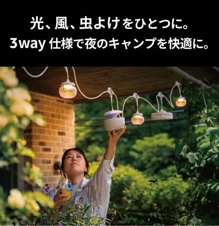 軒先に吊るしたGLOWNAのライトに手を伸ばす女性