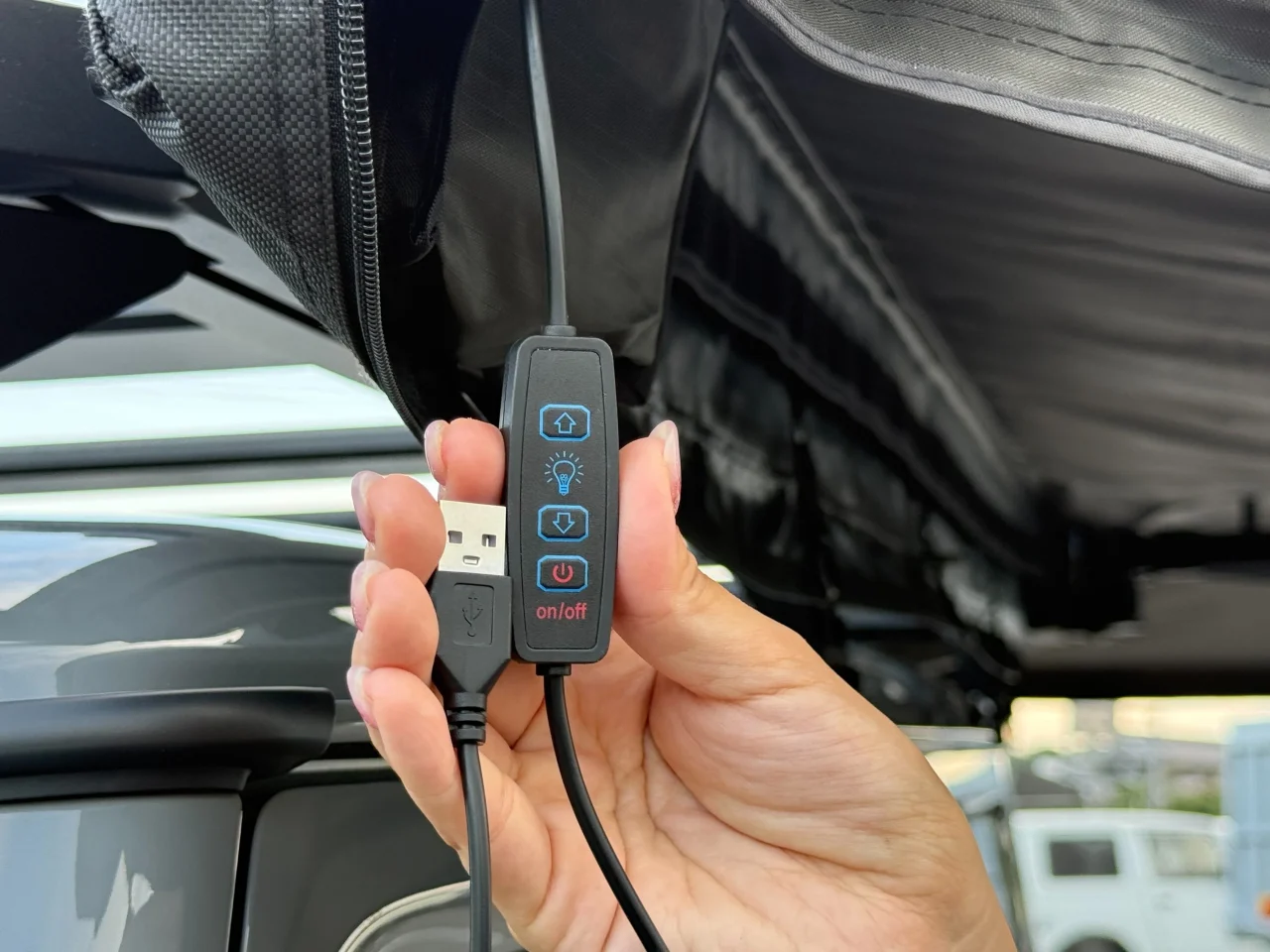 電源・調光ボタン。USBプラグ付きコントローラーを手で持つ様子